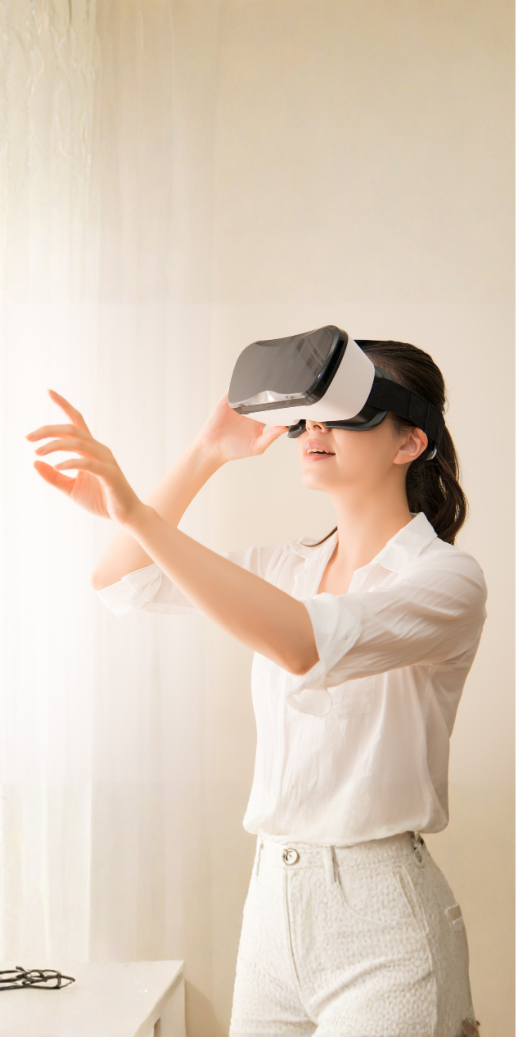 Frau mit VR-Brille, die mit einer Hand in den Raum greift und die virtuelle Umgebung erkundet.