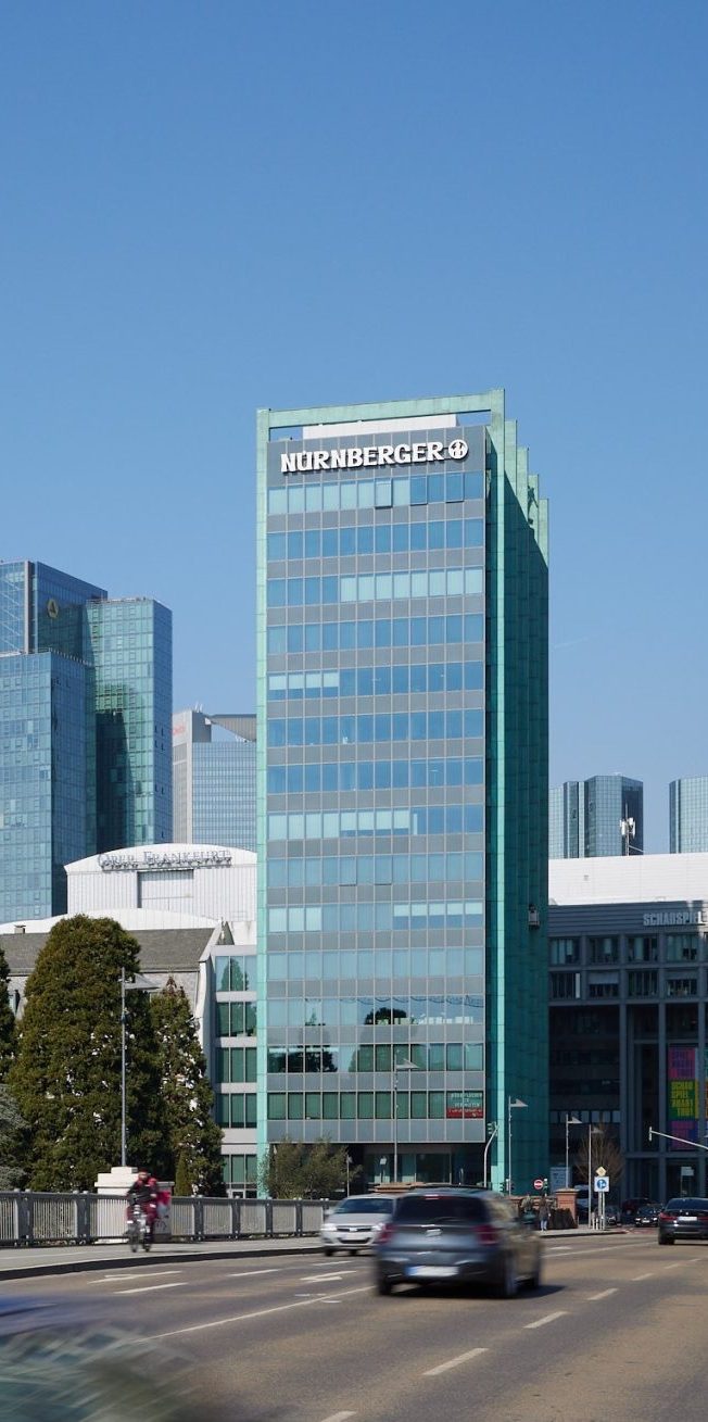 Modernes Bürogebäude mit Glasfassade und umliegender Stadtarchitektur.