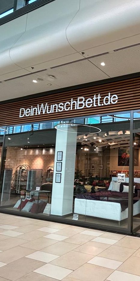 Shopfront von DeinWunschBett.de mit klarer Beschilderung und modernen Möbeln.